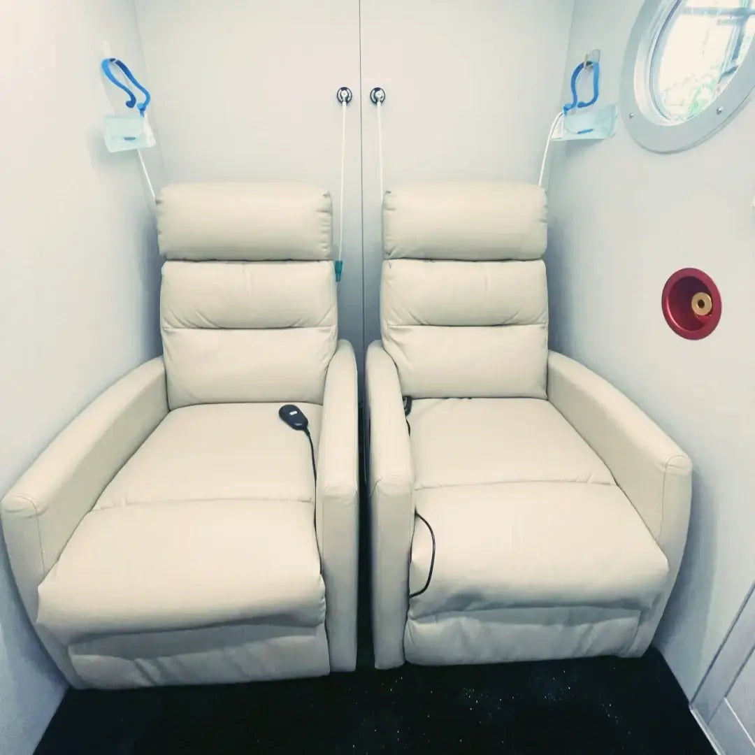 Interior view of the KOMJET Anti-Aging Cabin 2.0 with two comfortable leather reclining chairs.