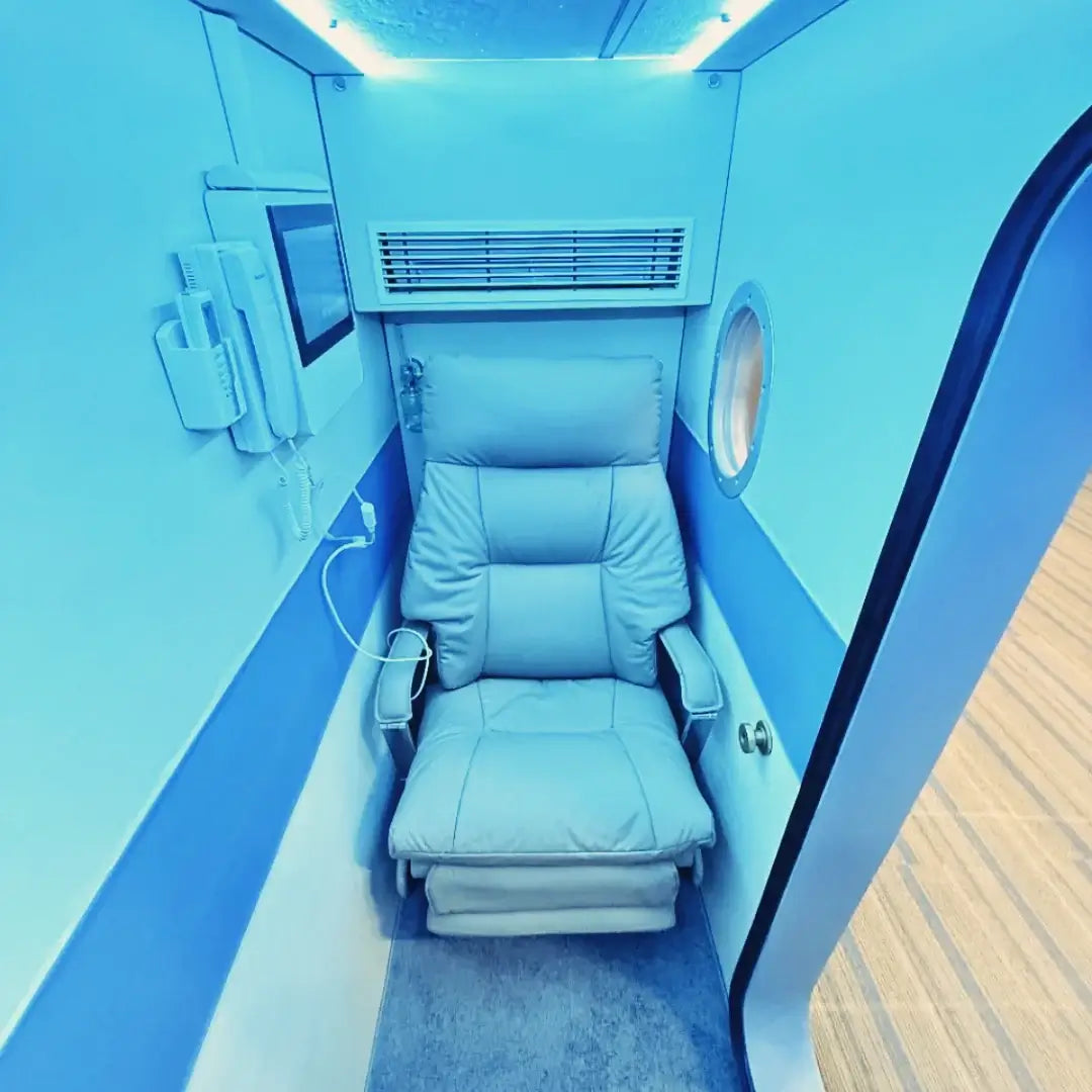 KOMJET Anti-Aging Cabin 2.0 interior with comfy chair and blue lighting, designed for wellness therapy.