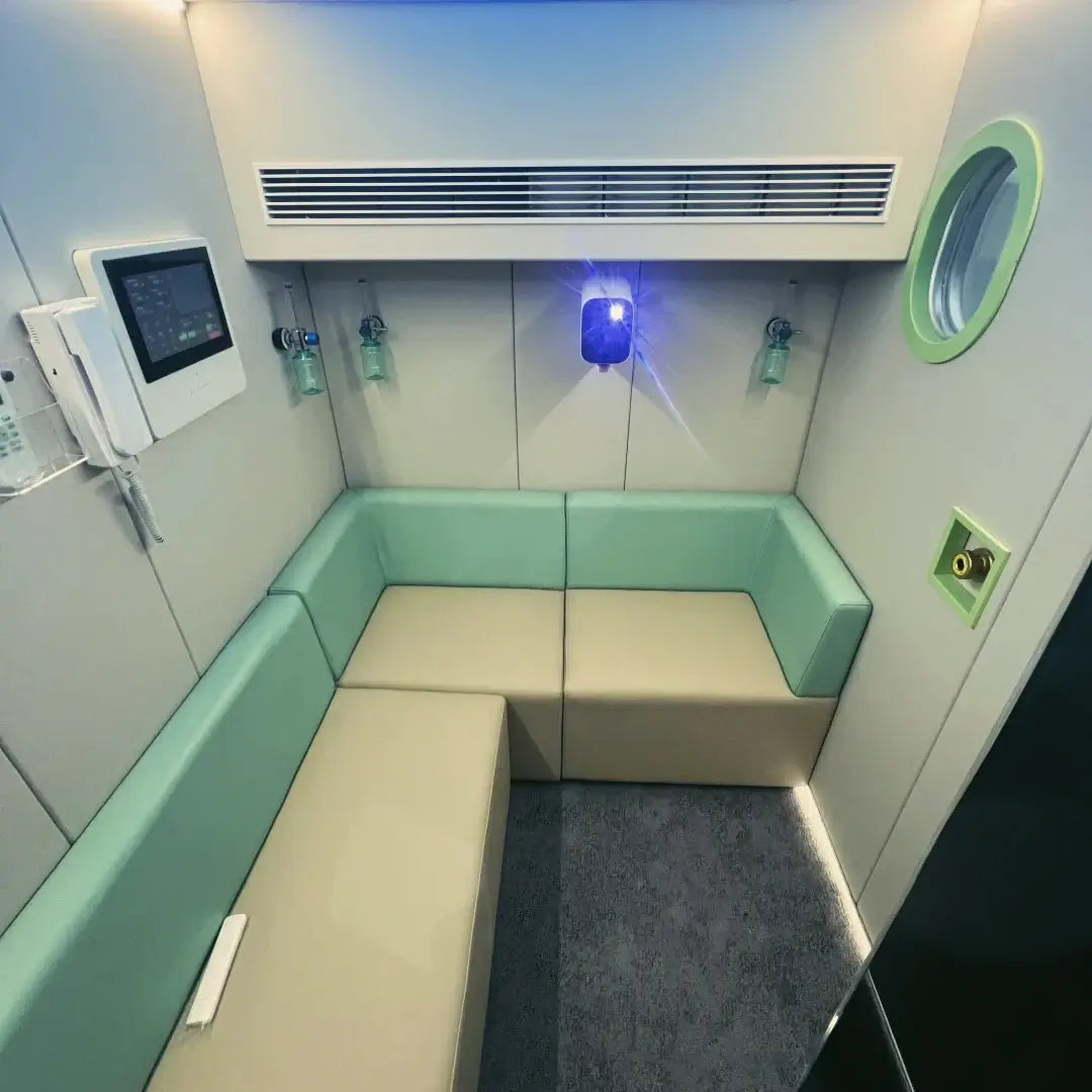 Interior view of KOMJET Anti-Aging Cabin 2.0 with seating and controls for hyperbaric oxygen therapy.